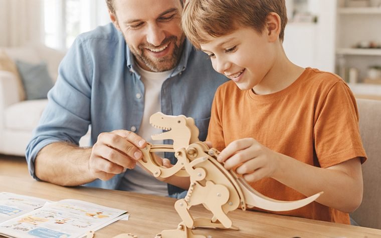 A parent and child assembling the Mechanical T-Rex together at home
